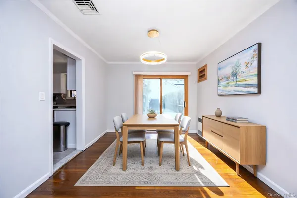 a dining room with wooden floor and large window