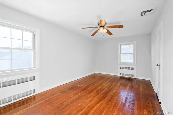 a view of a room with a window and wooden floor