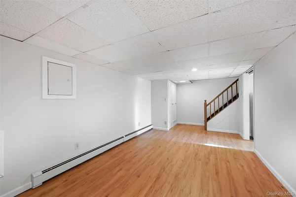 a view of an empty room with wooden floor and stairs