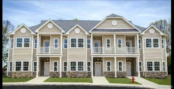 front view of a brick house with a yard