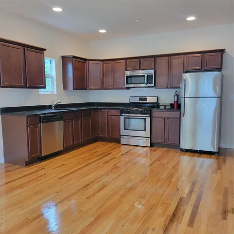 a kitchen with stainless steel appliances granite countertop a refrigerator and a stove top oven