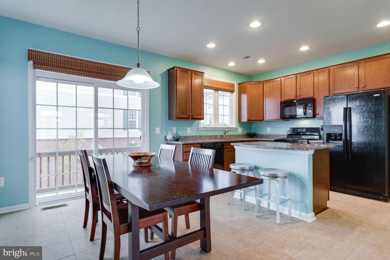 42724 Redpath Terrace Ashburn, VA 20147 - Photo 4 of 17 a kitchen with stainless steel appliances granite countertop a stove a refrigerator a kitchen island a table and chairs