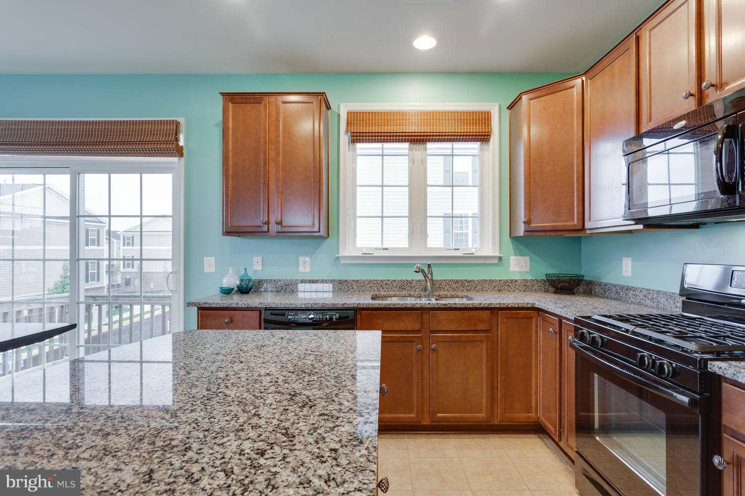 42724 Redpath Terrace Ashburn, VA 20147 - Photo 5 of 17 a kitchen with stainless steel appliances granite countertop a stove a sink and a microwave