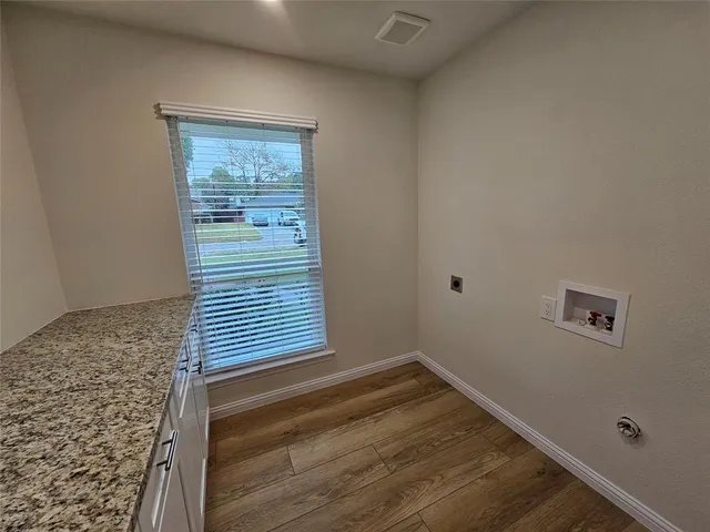 a view of empty room with wooden floor