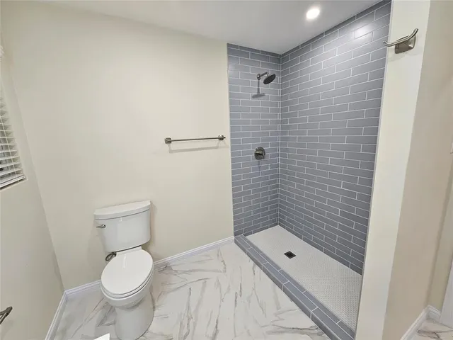 a bathroom with a toilet and a shower