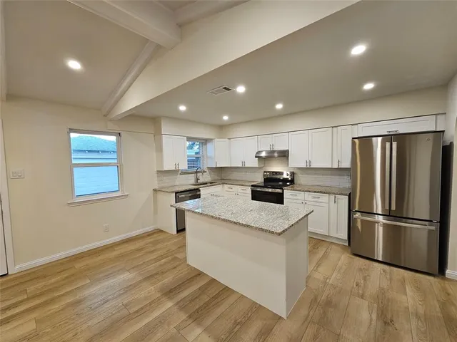 a kitchen with stainless steel appliances granite countertop a refrigerator sink and cabinets