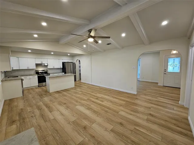 a view of kitchen with cabinets and refrigerator