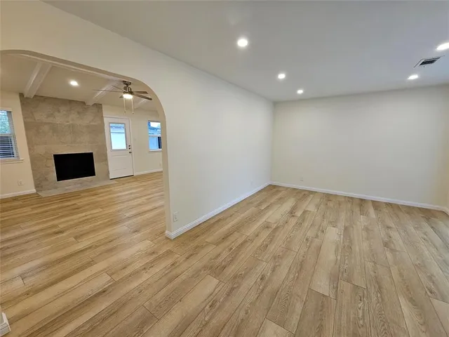 an empty room with wooden floor and entrance
