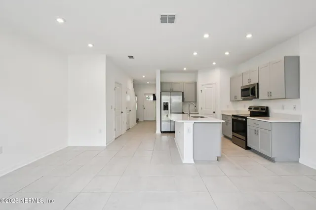a kitchen with white cabinets and stainless steel appliances