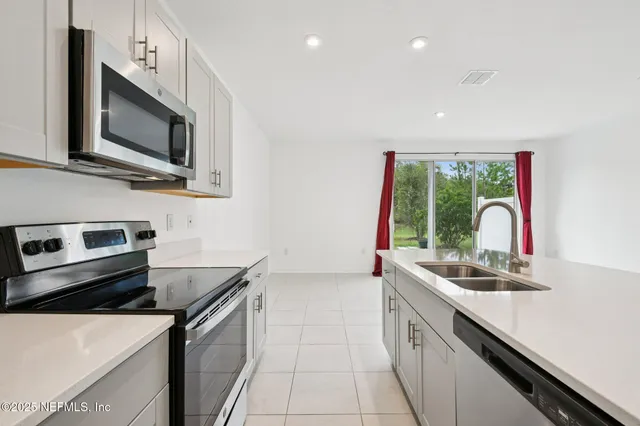 a kitchen with stainless steel appliances a sink stove and microwave