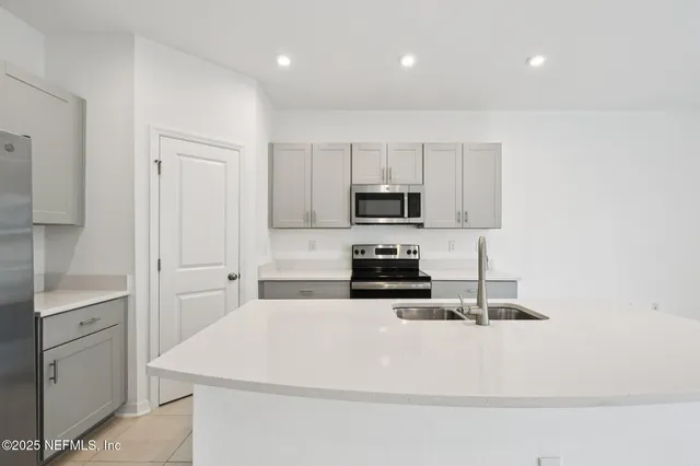 a kitchen with white cabinets and stainless steel appliances