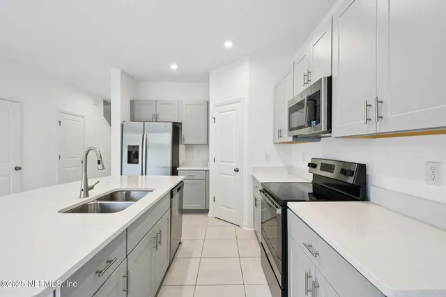 a kitchen with a sink a stove and cabinets