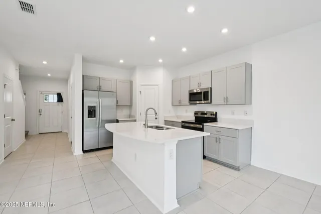 a kitchen with stainless steel appliances a refrigerator stove microwave and sink