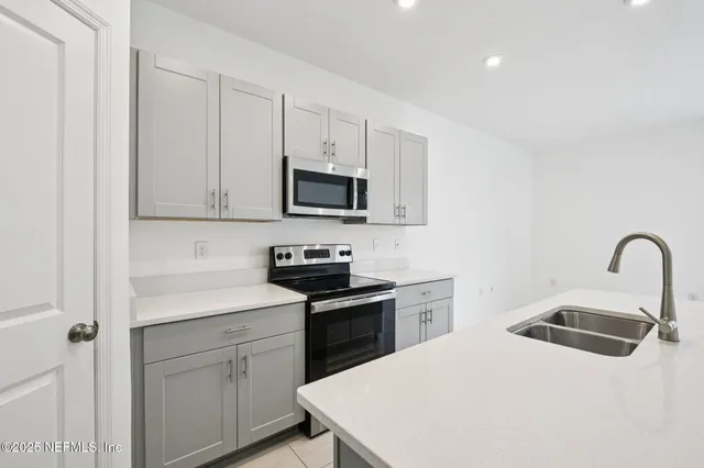 a kitchen with a sink a stove and cabinets