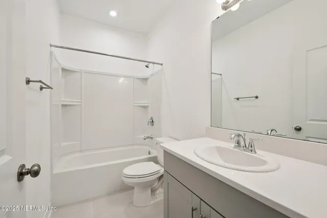 a bathroom with a granite countertop sink a toilet and shower