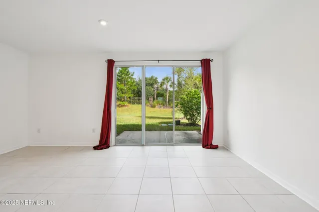 a view of an empty room with a fireplace and a floor to ceiling window