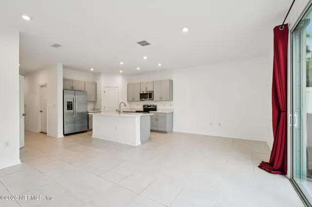 a view of kitchen with stainless steel appliances kitchen island sink refrigerator and stove