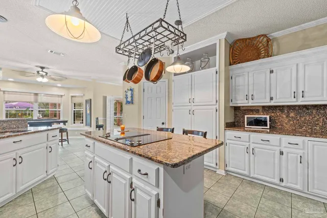 a kitchen with a sink dishwasher and white cabinets with wooden floor