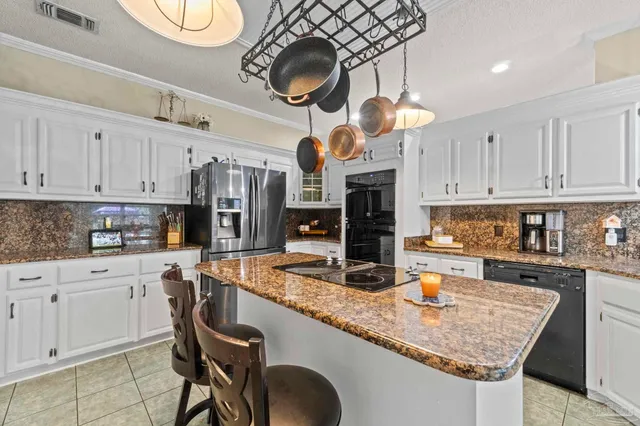 a kitchen with stainless steel appliances granite countertop a sink a stove and cabinets