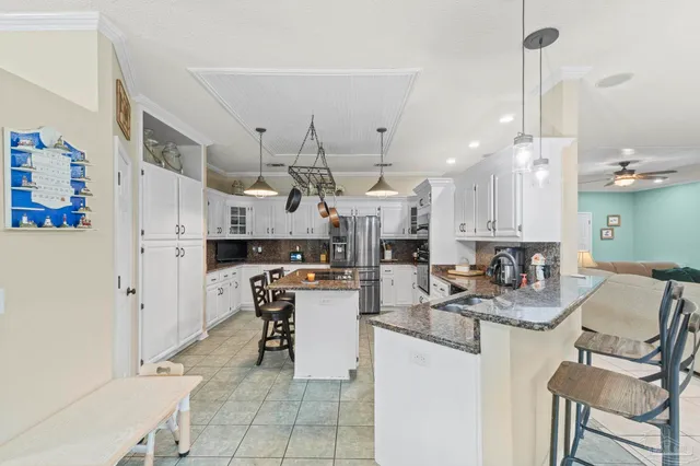 a kitchen with stainless steel appliances kitchen island granite countertop a refrigerator and a stove
