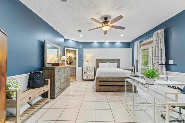 a spacious bedroom with a large bed and a chandelier