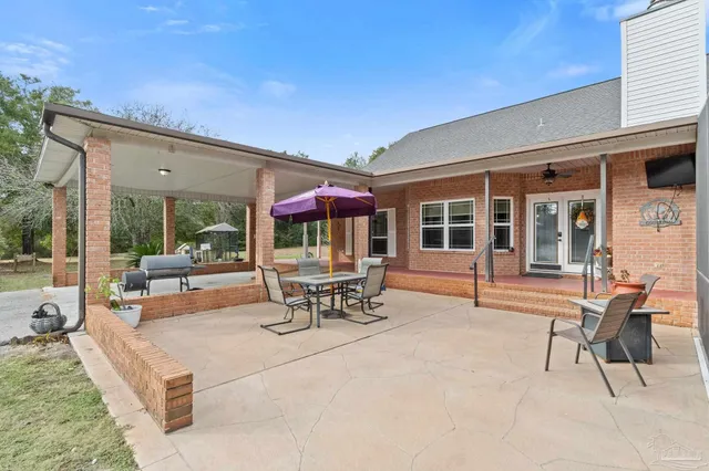 a view of a blue house with a big yard and large trees
