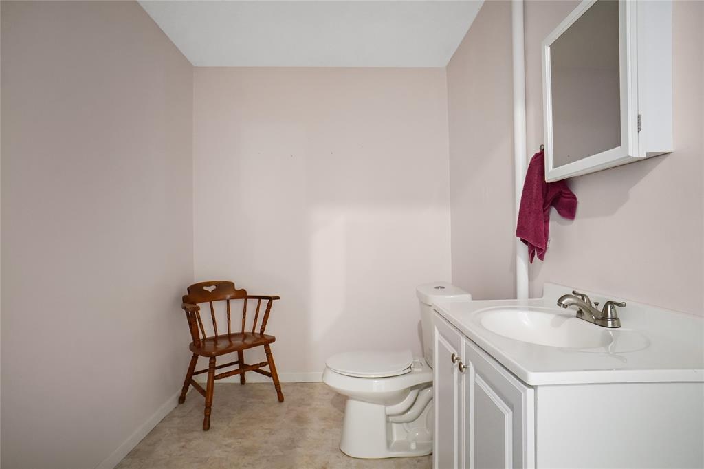 1092 West Highway 199 Springtown, TX 76082 - Photo 13 of 23 a bathroom with a toilet a sink and a mirror