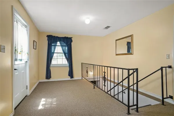 a view of entryway and hall with wooden floor