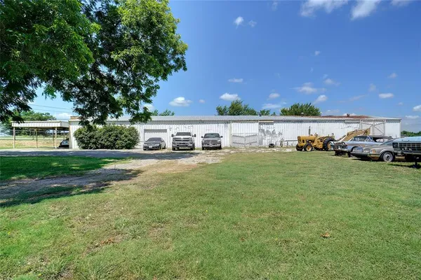 a view of a house with a big yard and large trees