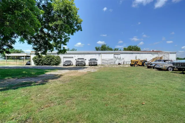 a view of a house with a big yard and large trees