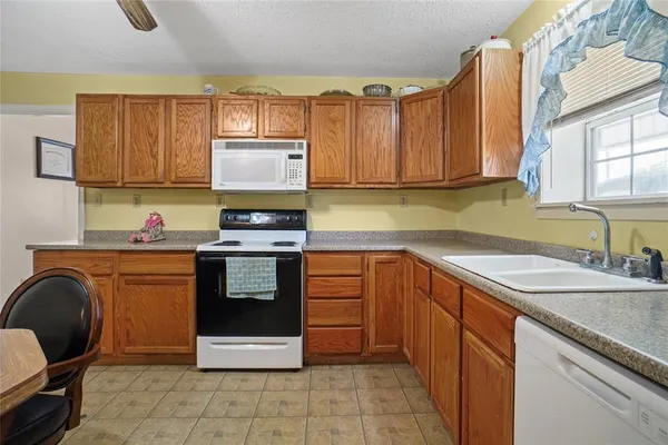 a kitchen with stainless steel appliances granite countertop a sink stove and cabinets
