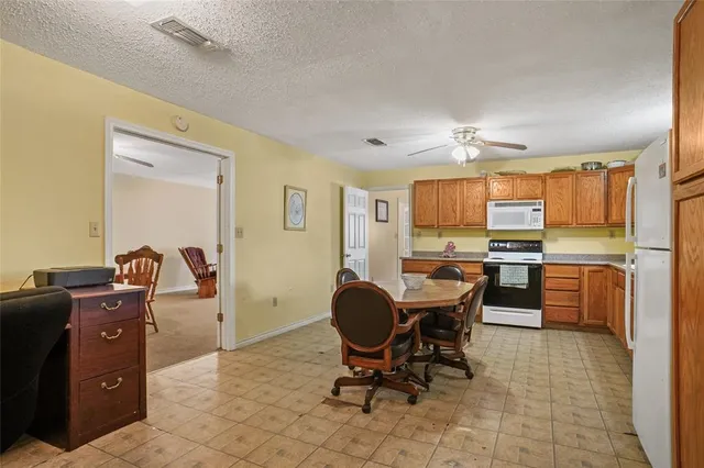 a view of a kitchen with kitchen island granite countertop a counter space dining table and stainless steel appliances