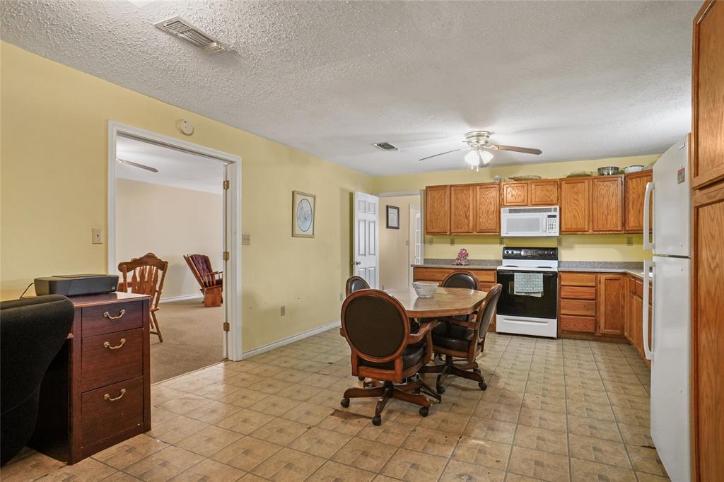 1092 West Highway 199 Springtown, TX 76082 - Photo 10 of 23 a view of a kitchen with kitchen island granite countertop a counter space dining table and stainless steel appliances