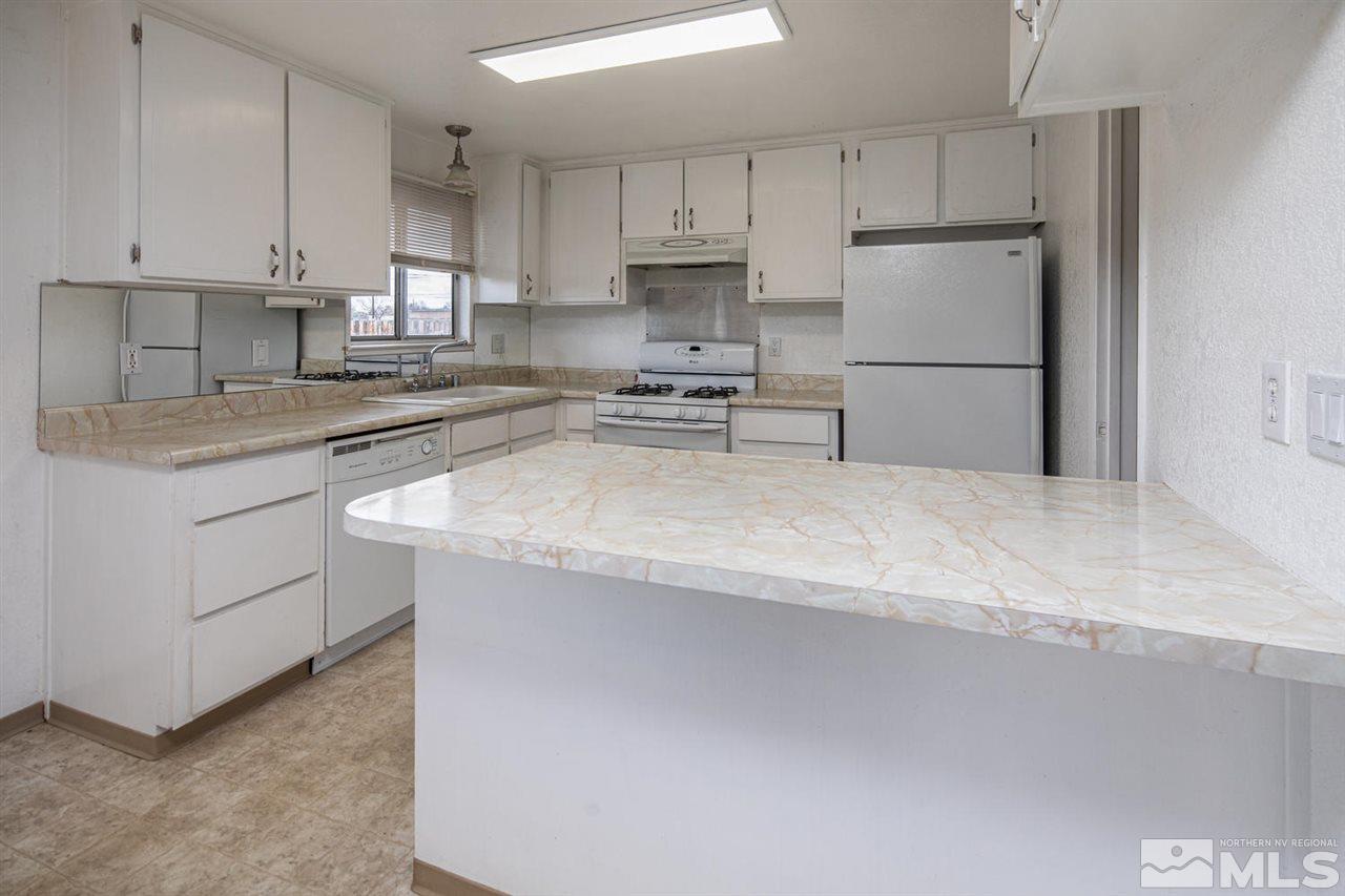 218 Ring Road Dayton, NV 89403 - Photo 8 of 25 a kitchen with refrigerator a stove a microwave and cabinets