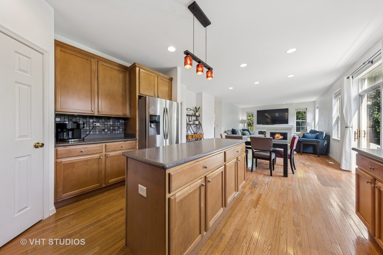13733 Meadow Lane Plainfield, IL 60544 - Photo 3 of 39 a kitchen with stainless steel appliances kitchen island granite countertop a refrigerator a stove a sink a dining table and chairs with wooden floor