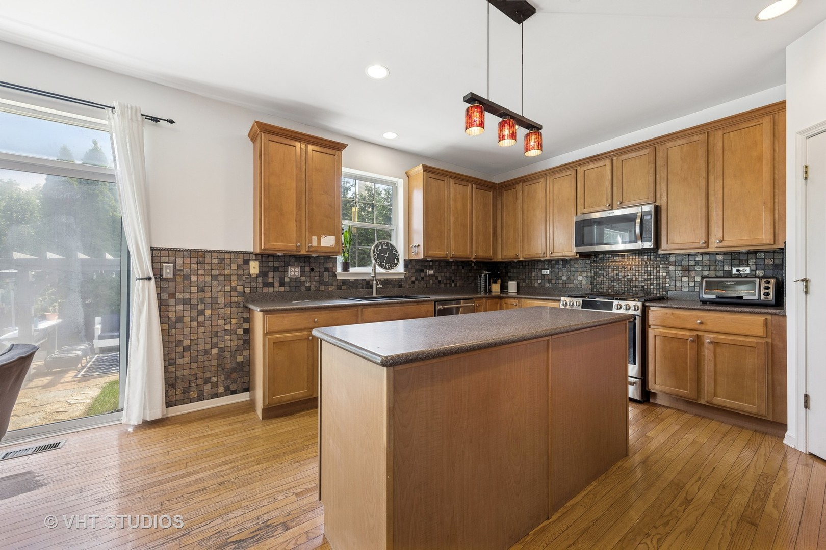 13733 Meadow Lane Plainfield, IL 60544 - Photo 6 of 39 a kitchen with granite countertop a sink cabinets and wooden floor