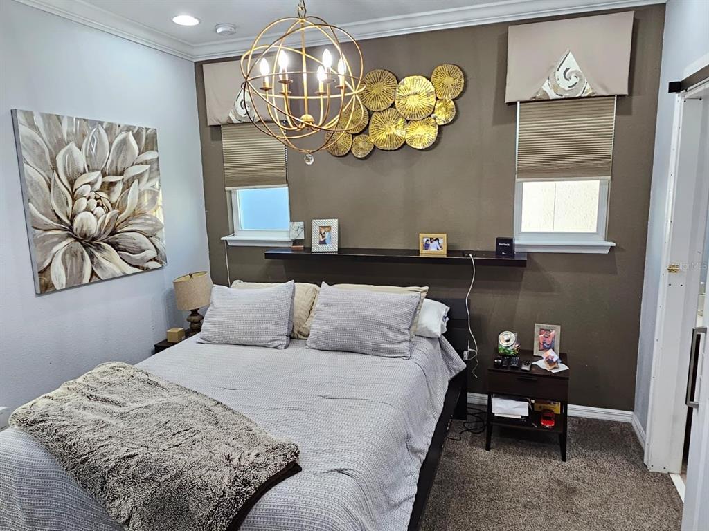 8552 Powder Ridge Trail Windermere, FL 34786 - Photo 25 of 30 a bedroom with a bed and a chandelier