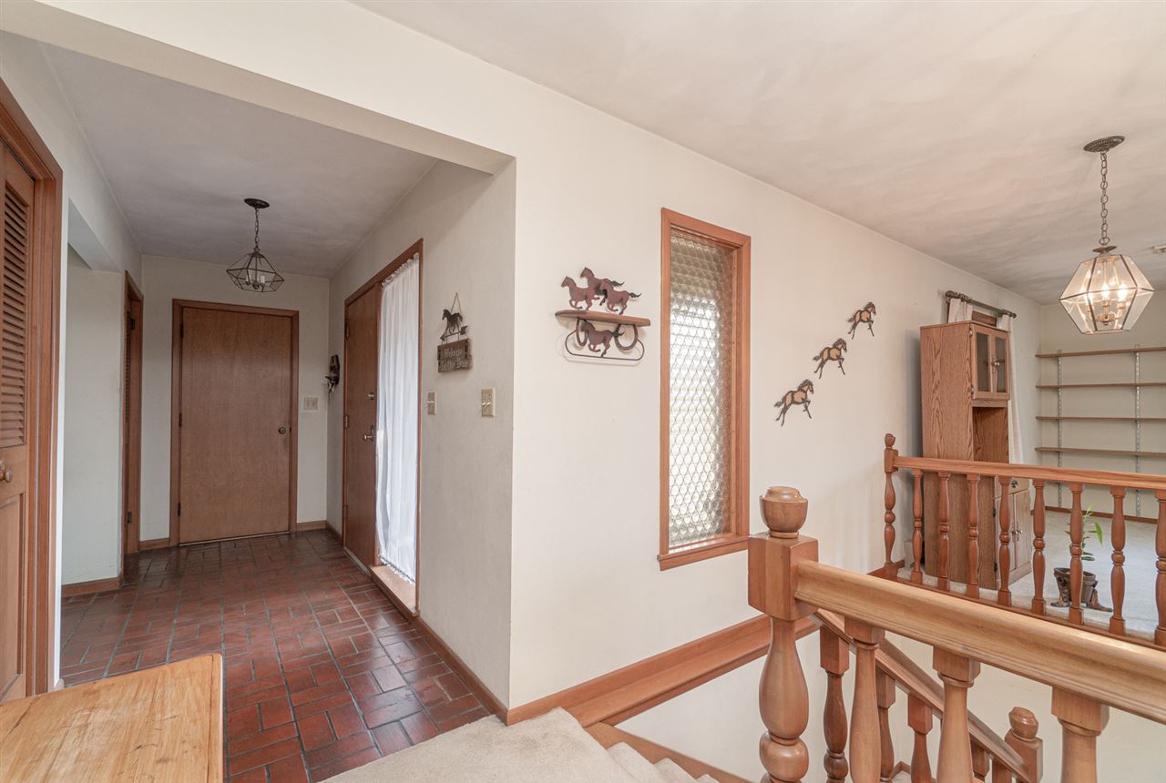 5760 Rotary Road Cherry Valley, IL 61016 - Photo 5 of 25 a view of a hallway with wooden floor and stairs