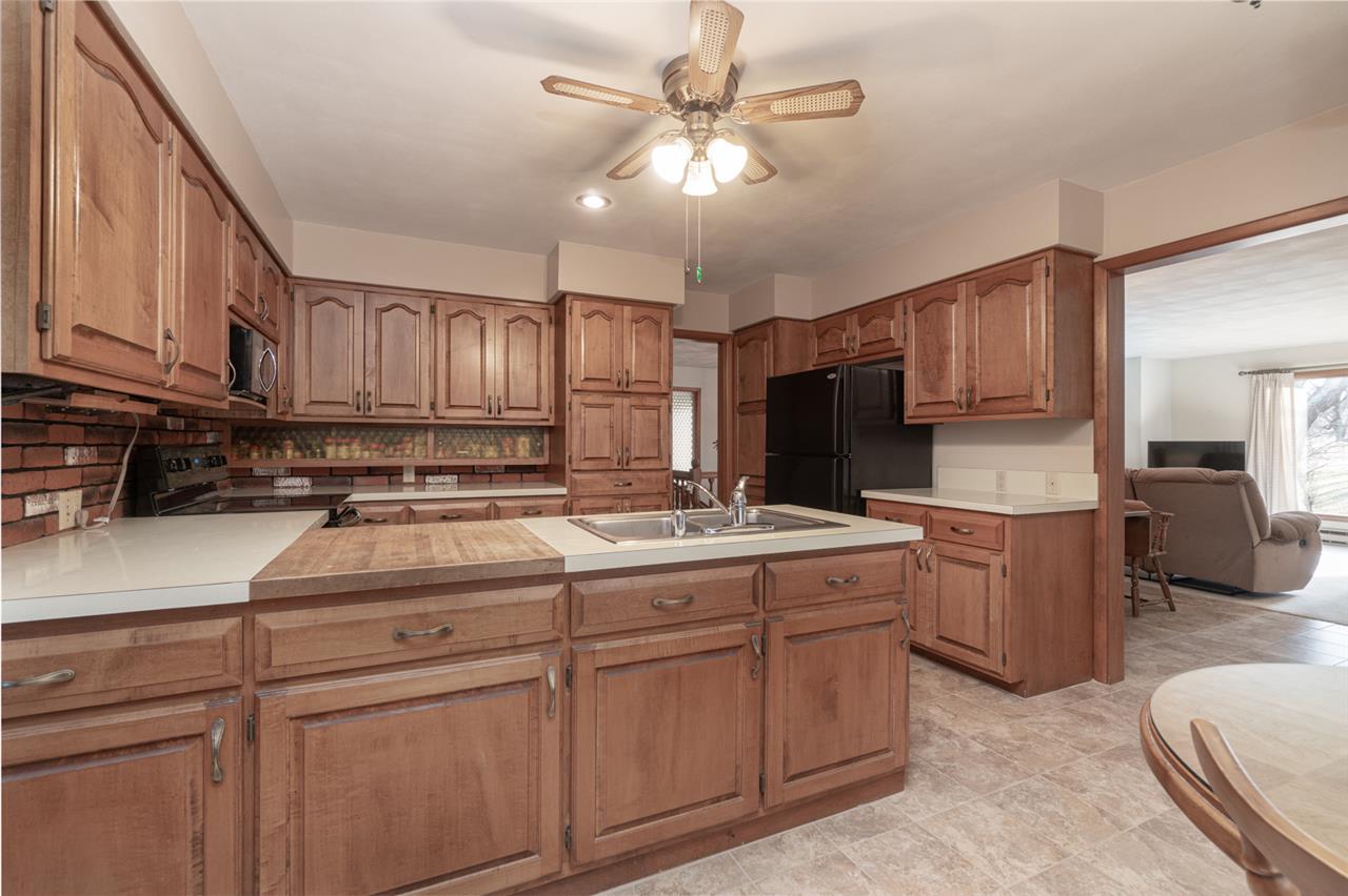 5760 Rotary Road Cherry Valley, IL 61016 - Photo 10 of 25 a kitchen with kitchen island granite countertop a stove cabinets and refrigerator
