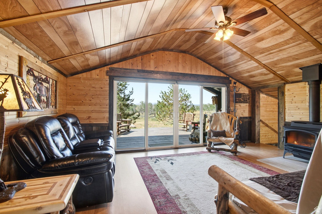 1663 Lancer Lane Evanston, UT 82930 - Photo 12 of 101 Wood-paneled vaulted ceiling with exposed beams, wood-finish flooring, and a ceiling fan