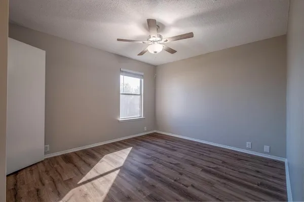 a view of a big room with wooden floor and a ceiling fan