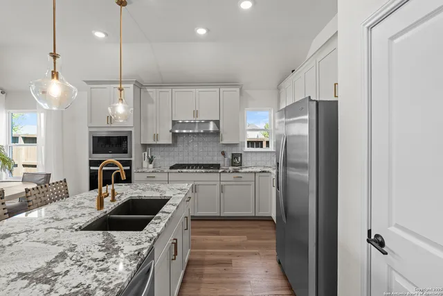 a kitchen with a refrigerator a sink a stove and oven
