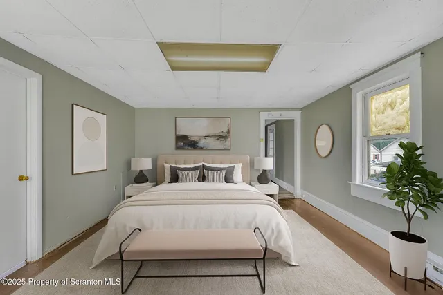 a bedroom with a bed and a potted plant