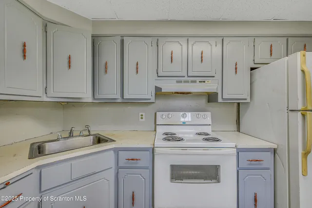 a kitchen with appliances a sink and cabinets