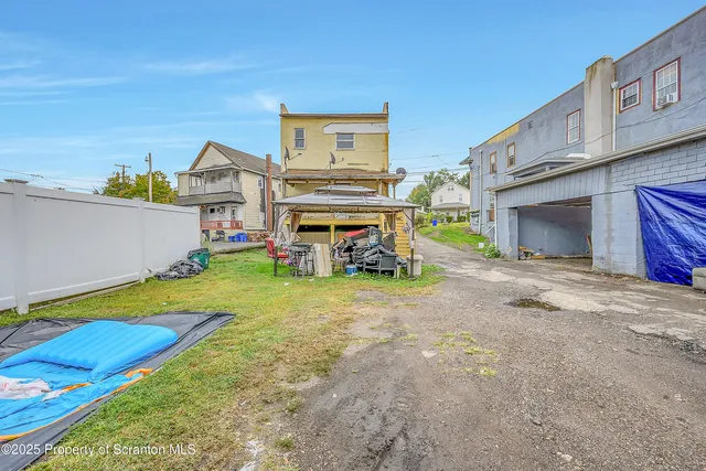 a view of a house with a backyard and a car park