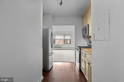 a view of a hallway with wooden floor and a cabinet