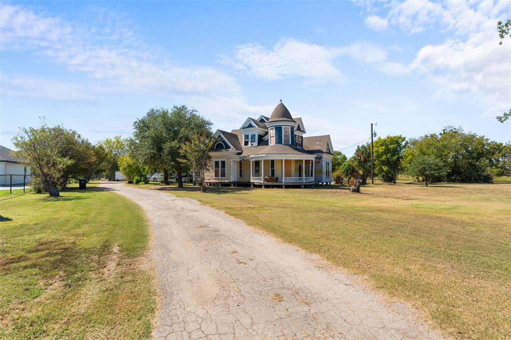 Victorian home with a porch, driveway, and a front yard