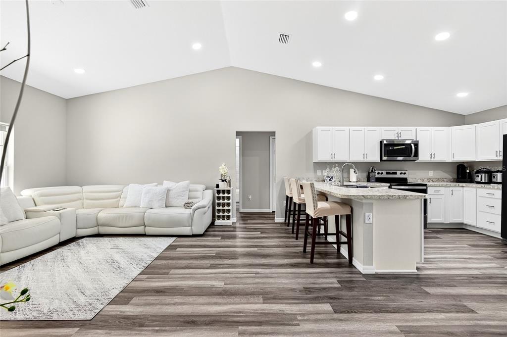 14862 Southwest 79 Terrace Road Dunnellon, FL 34432 - Photo 8 of 28 a living room with stainless steel appliances kitchen island granite countertop a couch and cabinets