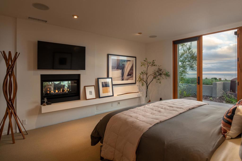 14014 Rue D Antibes Del Mar, CA 92014 - Photo 23 of 46 a bedroom with a balcony a bed and a fireplace