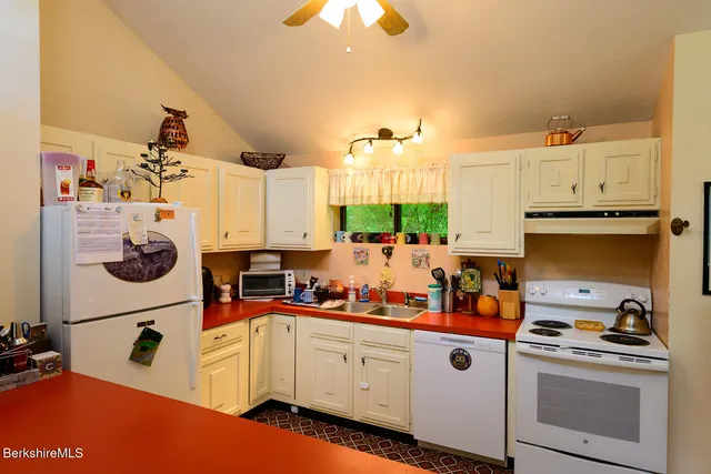a kitchen with white cabinets and sink